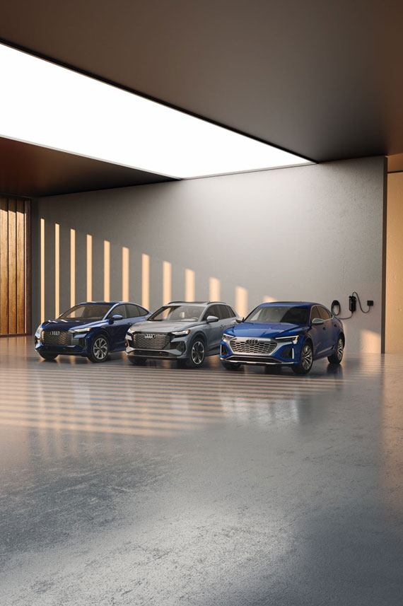 Group of Audi EV's parked inside a modern room.